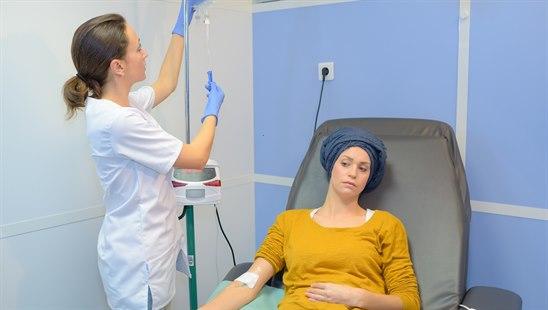 Illustrasjonsfotoet viser en lege og pasient. Pasienten sitter i en stol å får cellegiftbehandling.