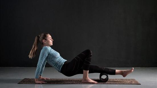 Illustrasjonsfoto av en kvinne som bruker en massasjerull under leggen.