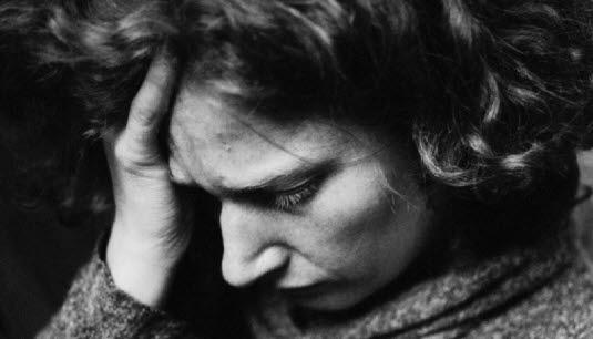 En dame som lener hode sitt mot hånden