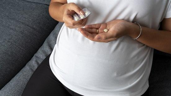 Illustrasjonsfoto av gravid kvinne med tablettbrett over gravidmagen