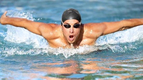 Illustrasjonsfoto av en mann som konkurrerer i svømming. Han bruker butterfly teknikk.