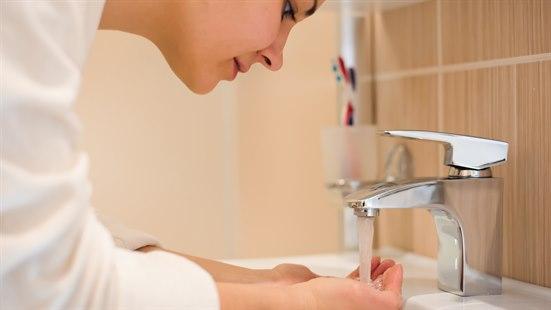 Illustrasjonsfoto av en ung kvinne som vasker hendene.
