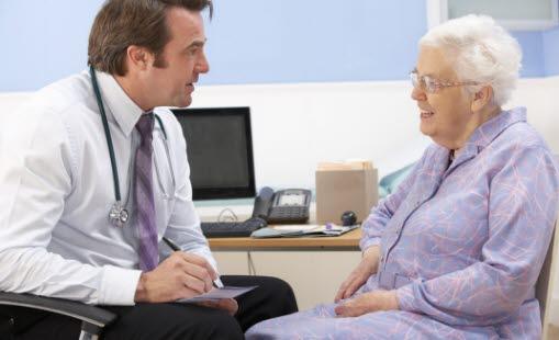 Illustrasjonsfotoet viser en eldre kvinne i samtale med sin mannlige lege