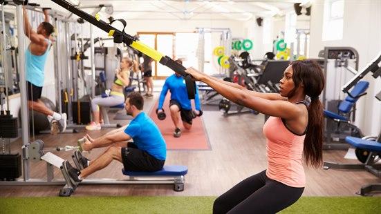 Illustrasjonsfoto som viser flere mennesker som trener på ulike styrkeapparater i et treningsstudio.