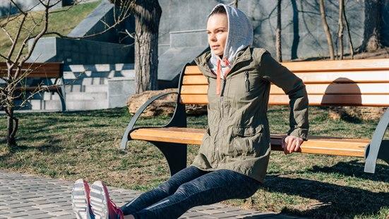 Ung kvinne trener ute i en park