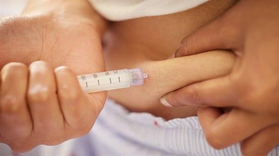 Person med fedme injiserer medisin i en fettvalk.