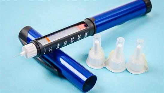 Bilde som viser blå insulinpenn med spiss og tre uåpnede spisser.