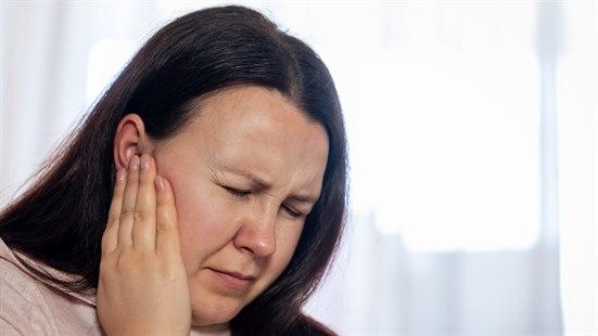 Illustrasjonsfotoet viser en kvinne som tar seg til øret