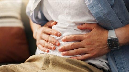 Illustrasjonsfoto av en person som har vondt i magen - som holder seg på magen.