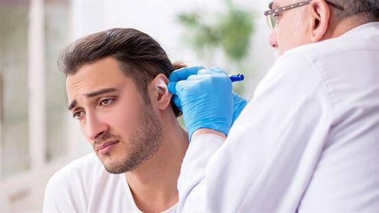 Illustrasjonsfotoet viser en ung mann som får øret sitt undersøkt av en lege