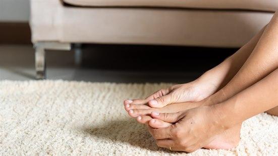 Illustrasjonsfotoet viser nærbilde av føttene til en person som holder på begge føttene