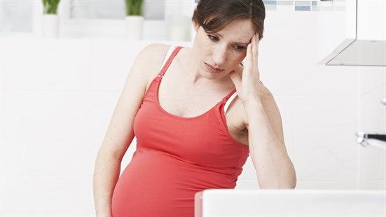 En gravid kvinne som sitter på badet, og støtter seg til toalettet, illustrerer en gravid kvinne som har svangerskapskvalme