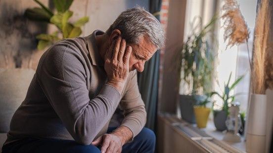 Illustrasjonsfotoet viser en eldre mann som tar seg til øret