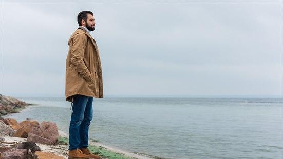 Illustrasjonsfoto av en mann som står ved stranden og skuer utover sjøen. 