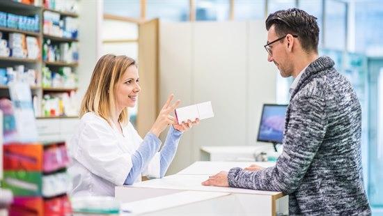 Mann som handler medisin på et apotek fra en kvinnelig apoteker.