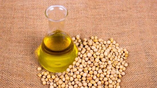 Illustrasjonsfoto av soyaolje i en karaffel, med noen kikerter ved siden av, alt plassert på en striesekk.