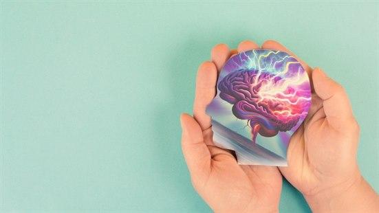 Illustrasjonen viser en utskjært pappfigur av et menneskelig hode som holdes i to hender vendt med håndflatene opp. På pappfiguren er det tegnet en fargerik illustrasjon av hjernen. Enkelte lyn slår ned på hjernen.. 