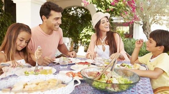Familie spiser sunt måltid ute i hagen.