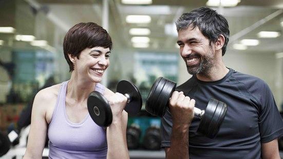 Illustrasjonsfoto: En mann og en kvinne løfter vekter ved siden av hverandre i et treningsstudio.