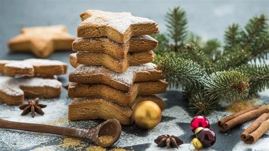 Illustrasjonsbilde av julekaker, julepynt og julekrydder som ligger på et bord. 