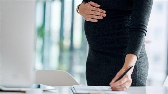 Illustrasjonsfotoet viser en gravid kvinne som holder på sin mage mens hun noterer på et ark