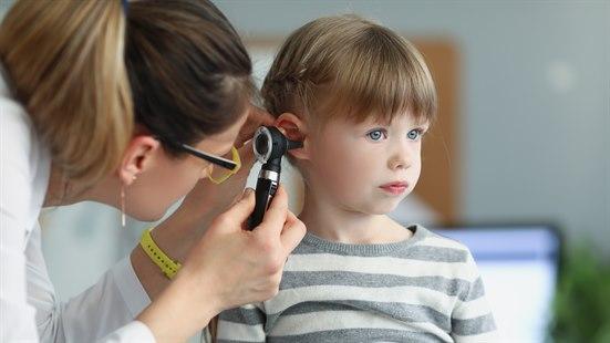 Illustrasjonsfotoet viser en kvinnelig lege som undersøker øret til et jentebarn