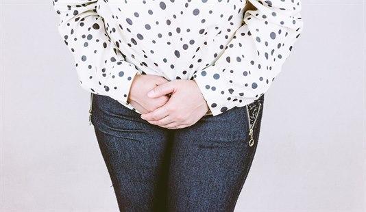 Tissetrengt kvinne, avbildet fra knær til skuldre.