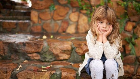 Illustrasjonsfoto av ei jente som sitter på en steintrapp og kjeder seg.