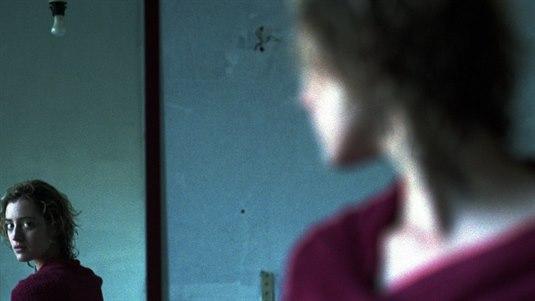 Ung kvinne ser på seg selv i et speil