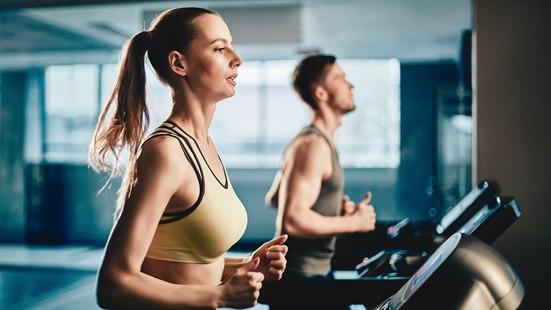 Illustrasjonsfoto av ei dame og en mann som mløper på tredemølle. 