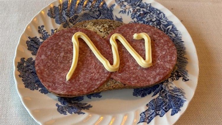 Foto av ei brødskive med salami og majones.