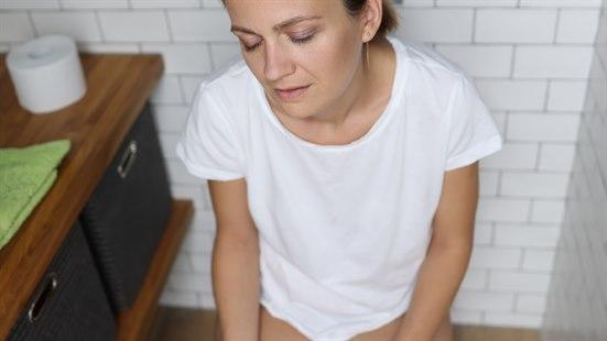 Sliten dame som sitter på do