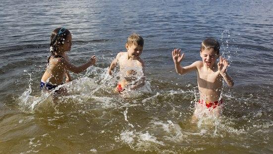 Illustrasjonsfotoet viser tre barn som leker i et vann