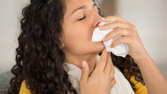 Illustrasjonsfotoet viser en kvinne som holder et papir foran neste grunnet neseblødning