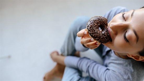 Illustrasjonsfoto av en kvinne som spise donout.