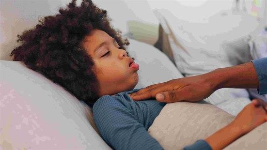 Illustrasjonsfoto: Syk, liten gutt som ligger i sengen og hoster. 