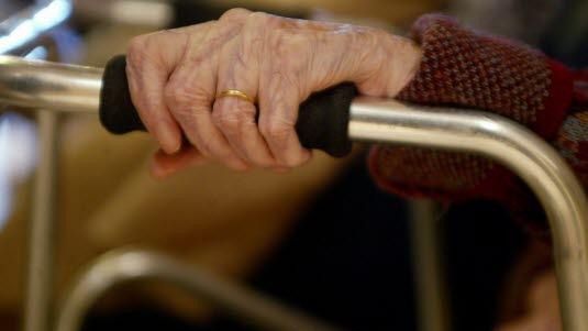 Illustrasjonsfotoet viser en nærbildet av en eldre hånd som holder på et håndtak til en rullator