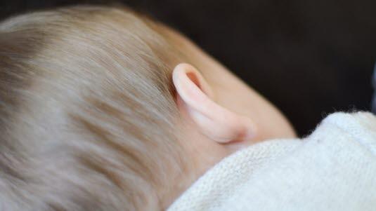 Illustrasjonsfotoet viser et barn sett bakfra, med fokus på øret