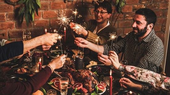 Illustrasjonsfoto av mennesker som sitter rundt et fint pyntet bord med julemat og skåler