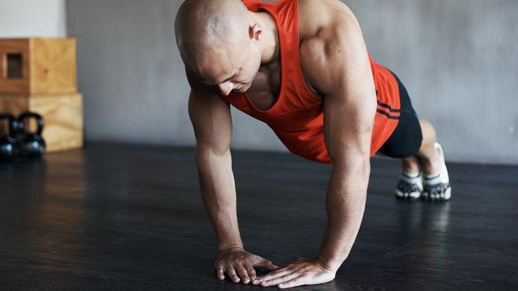 Illustrasjonsfoto: Bilde forfra av mann som tar armhevinger med tommelfinger og pekefinger mot hverandre, slik at mellomrommet blir diamantformet.