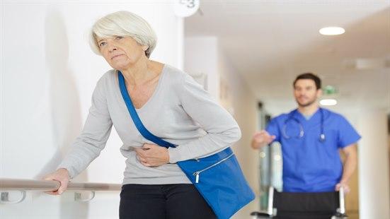 Slagpasient som trener i skranke under oppsyn.