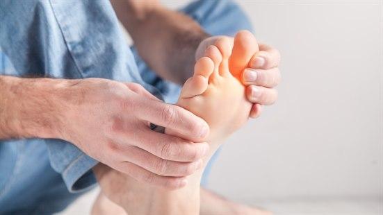 Illustrasjonsfotoet viser en person som holder på foten sin