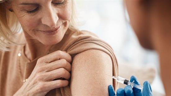 Illustrasjonsbilde av en eldre kvinne som får vaksine