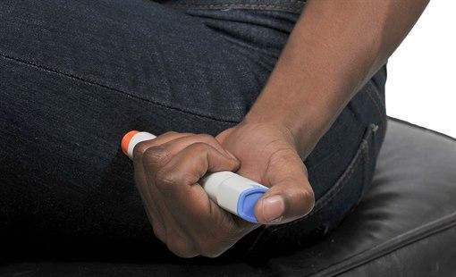 Illustrasjonsfoto viser en hånd som holder en injeksjonpenn mot utsiden av låret.