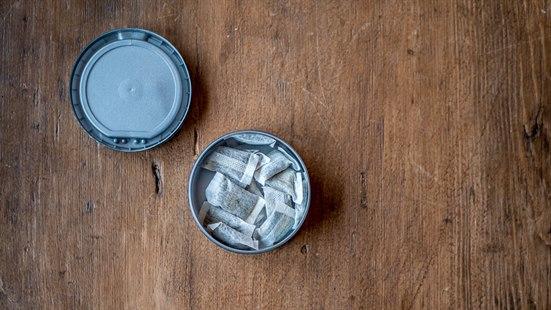 Illustrasjonsfoto av en snusboks som ligger på et trebord. 