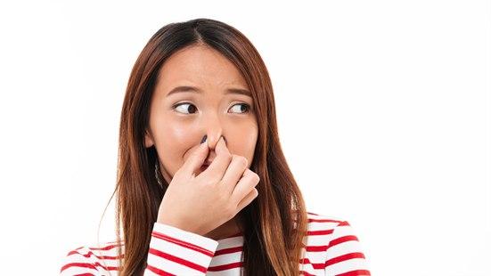 Illustrasjonsfoto av en ung kvinne som holder seg for nesen.