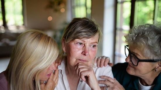 Illustrasjonsfoto av tre kvnner som sitter nært sammen og prater. 