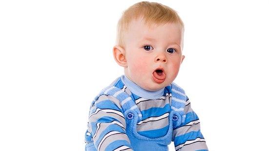 Et barn i stripete genser og blå teddy selebukse som hoster