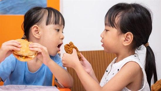 To kinesiske barn som spiser brød.