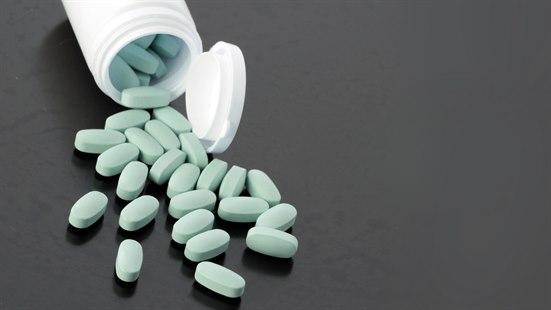 Illustrasjonsfotoet viser en veltet pilleboks med grønne tabletter